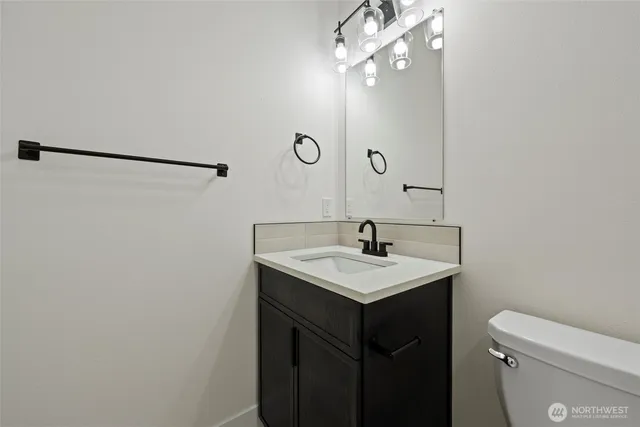 a bathroom with a sink a toilet a mirror and shower