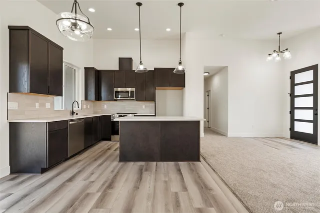 a large kitchen with kitchen island a sink stainless steel appliances and cabinets
