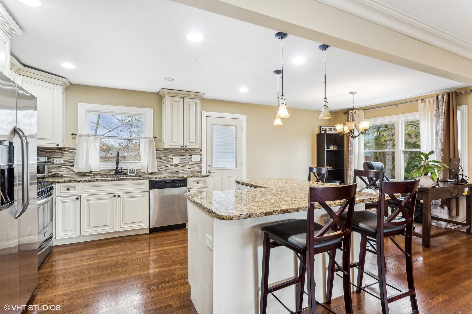 9001 East Prairie Road Evanston, IL 60203 - Photo 6 of 19 a kitchen with granite countertop a table chairs stove and white cabinets