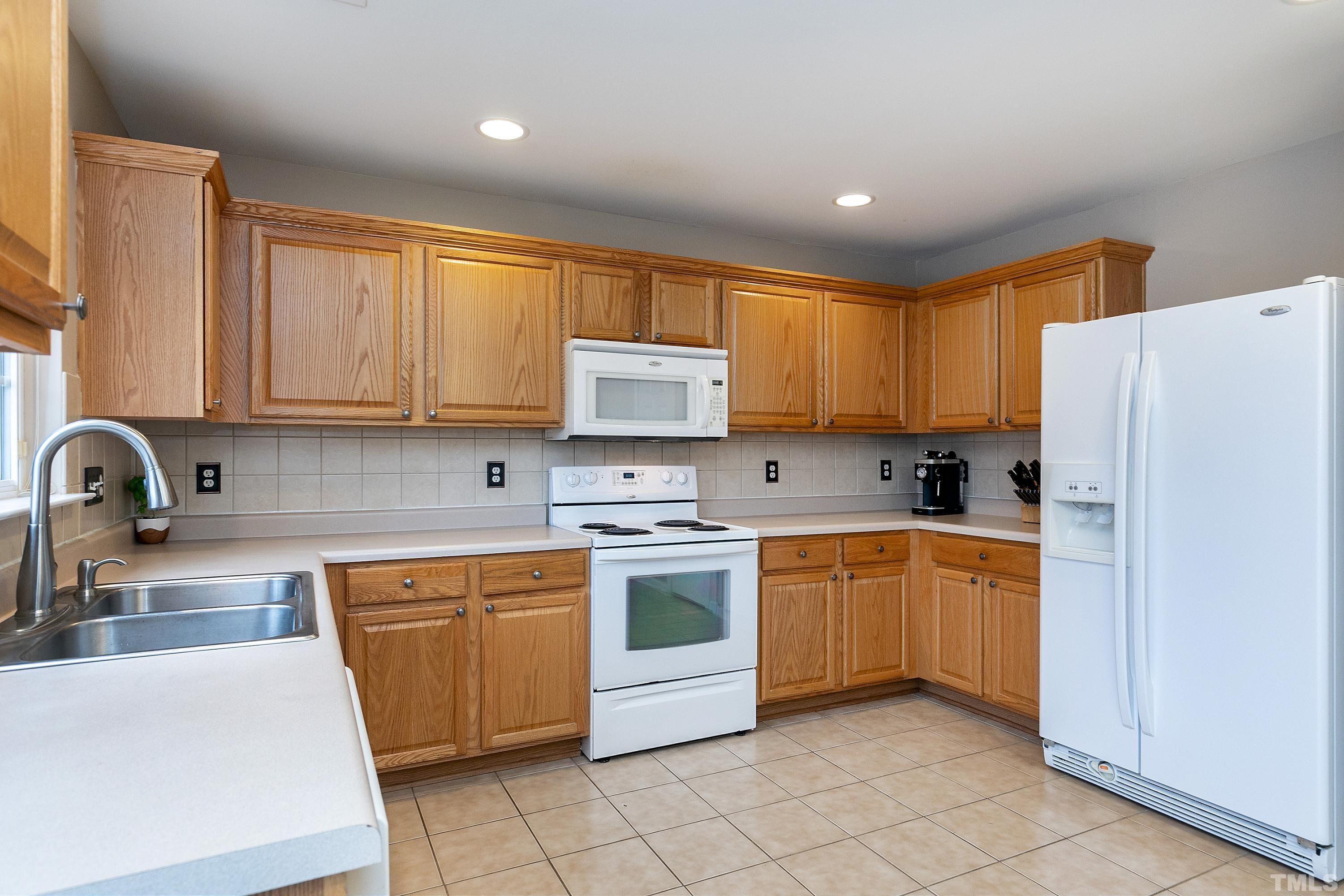 160 Solheim Lane Raleigh, NC 27603 - Photo 11 of 33 a kitchen with stainless steel appliances granite countertop white stove top oven and refrigerator