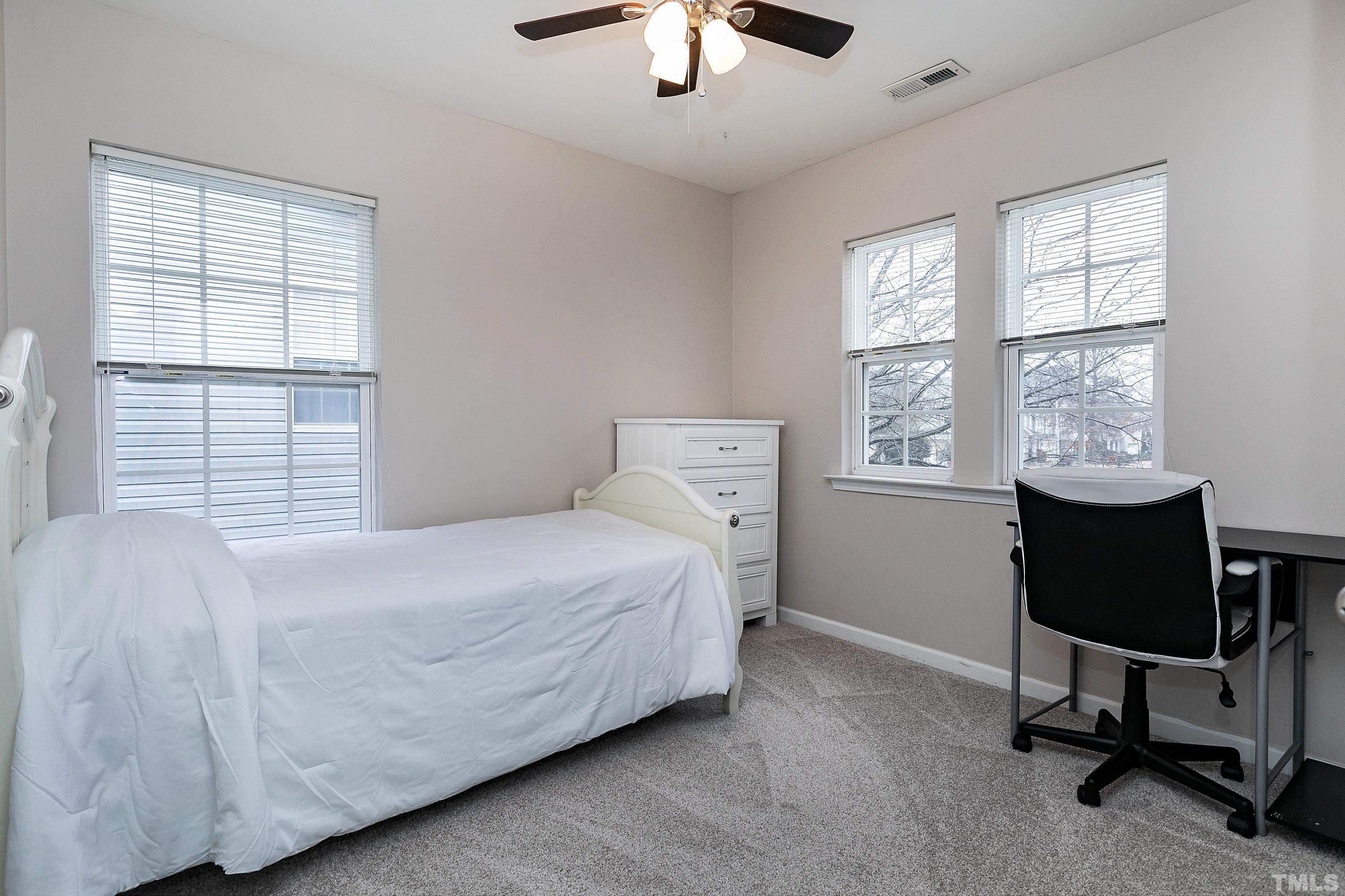160 Solheim Lane Raleigh, NC 27603 - Photo 21 of 33 a bedroom with a bed a chair and a chandelier
