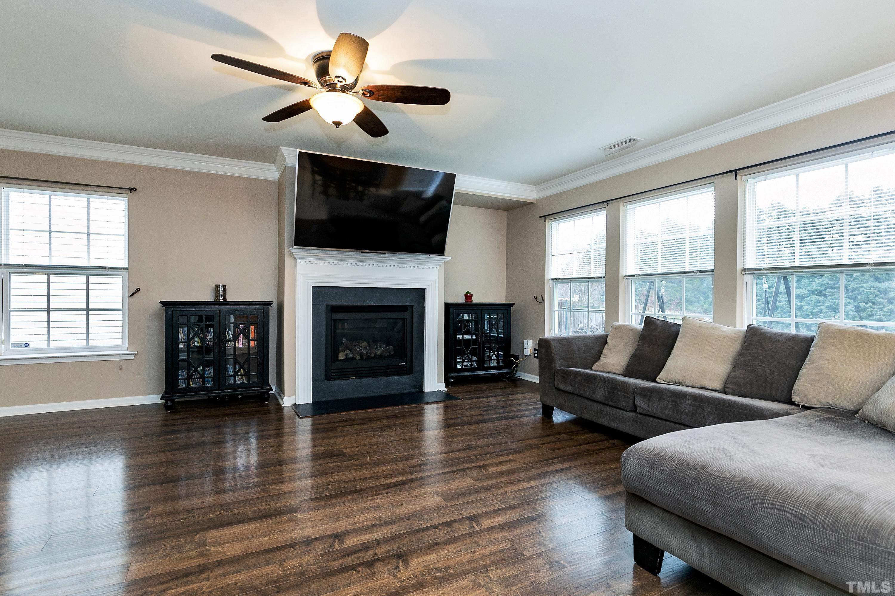 160 Solheim Lane Raleigh, NC 27603 - Photo 3 of 33 a living room with furniture a fireplace and a flat screen tv