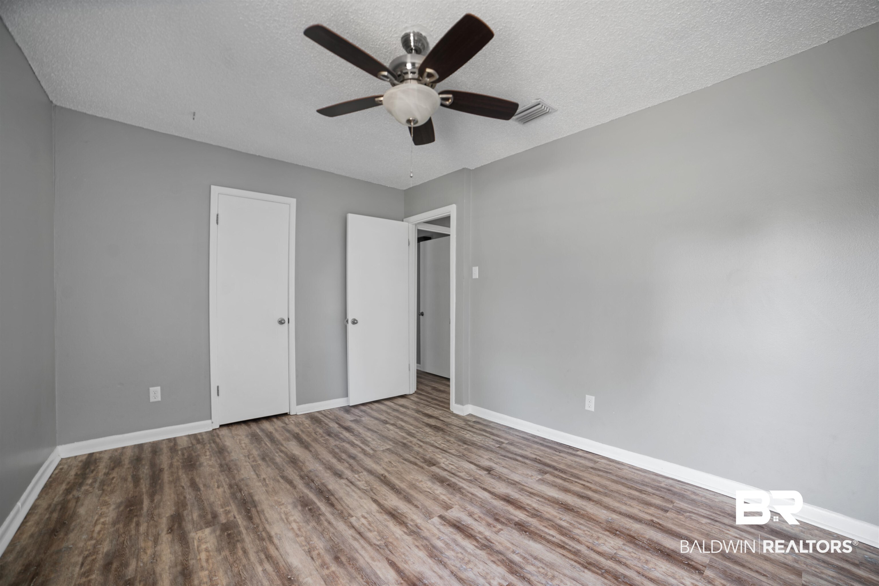 804 Regents Drive West Mobile, AL 36609 - Photo 26 of 35 Unfurnished bedroom with a textured ceiling, wood finished floors, and a ceiling fan