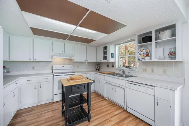 a kitchen with a sink a counter top space stainless steel appliances and cabinets