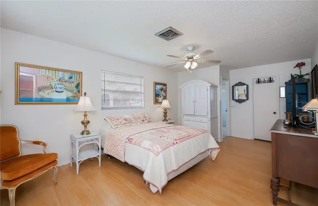 a bedroom with a bed a dresser and flat screen tv