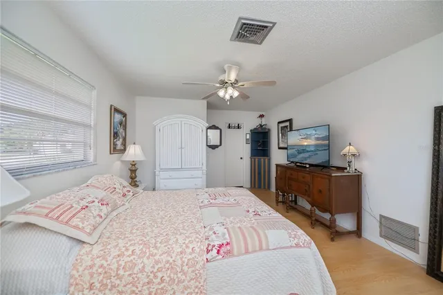 a bedroom with a large bed and a chandelier