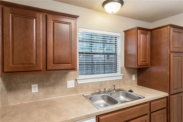 a kitchen with stainless steel appliances granite countertop wooden cabinets a sink and a window