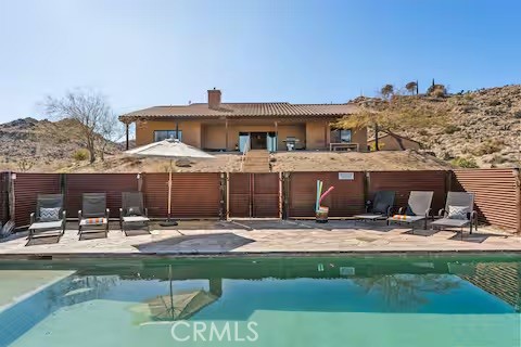 62398 Lilley Road Joshua Tree, CA 92252 - Photo 2 of 70 a front view of a house with swimming pool and sitting area