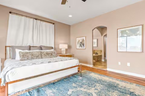 62398 Lilley Road Joshua Tree, CA 92252 - Photo 22 of 70 a bedroom with a large bed and a chandelier