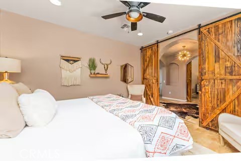 62398 Lilley Road Joshua Tree, CA 92252 - Photo 44 of 70 a bedroom with a bed ceiling fan and a large mirror