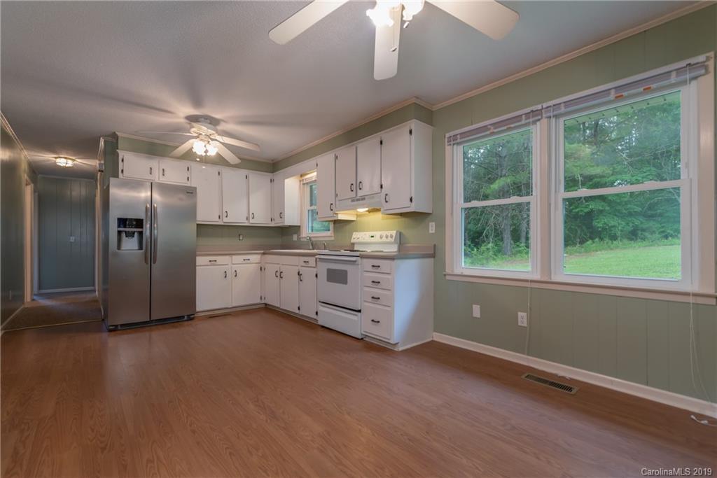 2760 Maple Creek Road Rutherfordton, NC 28139 - Photo 8 of 26 a kitchen with stainless steel appliances granite countertop a refrigerator a sink dishwasher a stove and white countertops with wooden floor