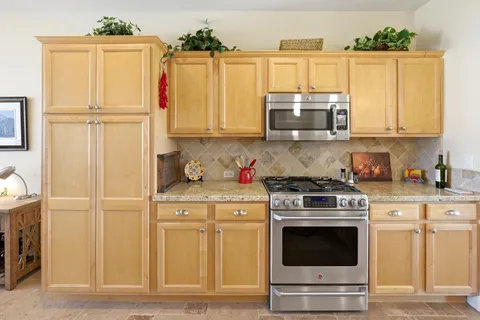 a kitchen with a stove and white cabinets
