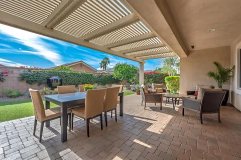 a view of a patio with a dining table and chairs under an umbrella