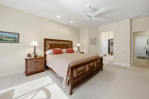 a spacious bedroom with a bed and a chandelier