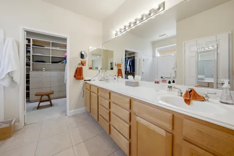 a spacious bathroom with a double vanity sink mirror and bathtub