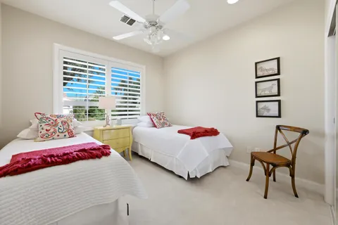 a bedroom with two bed and a chandelier