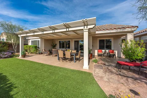 a view of a patio with table and chairs potted plants and a large tree