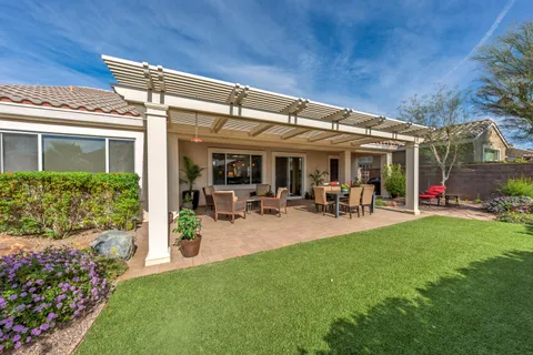 a view of a patio with table and chairs potted plants and floor to ceiling window and wooden floor