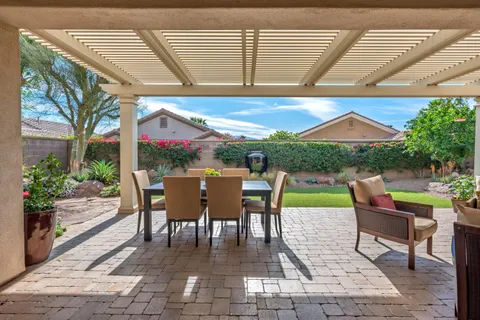 a view of a patio with a dining table and chairs with wooden floor and fence