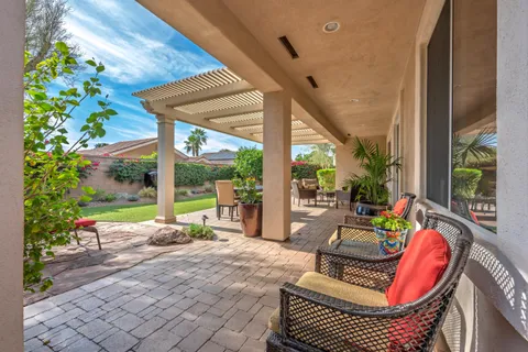 a view of a patio with couches table and chairs and potted plants