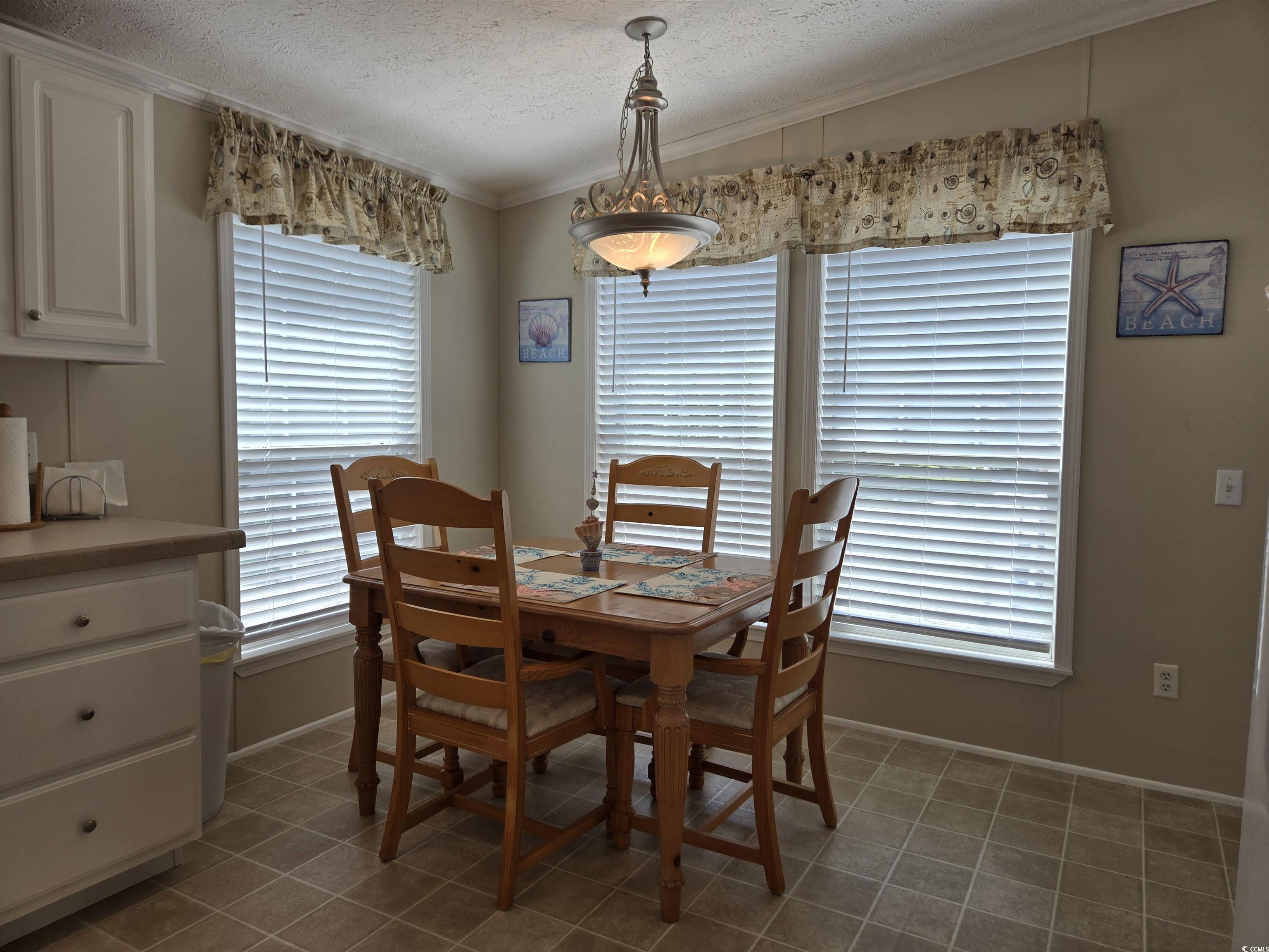 337 Clam Shell Circle Murrells Inlet, SC 29576 - Photo 15 of 29 Dining space featuring a textured ceiling, tile patterned flooring, and ornamental molding