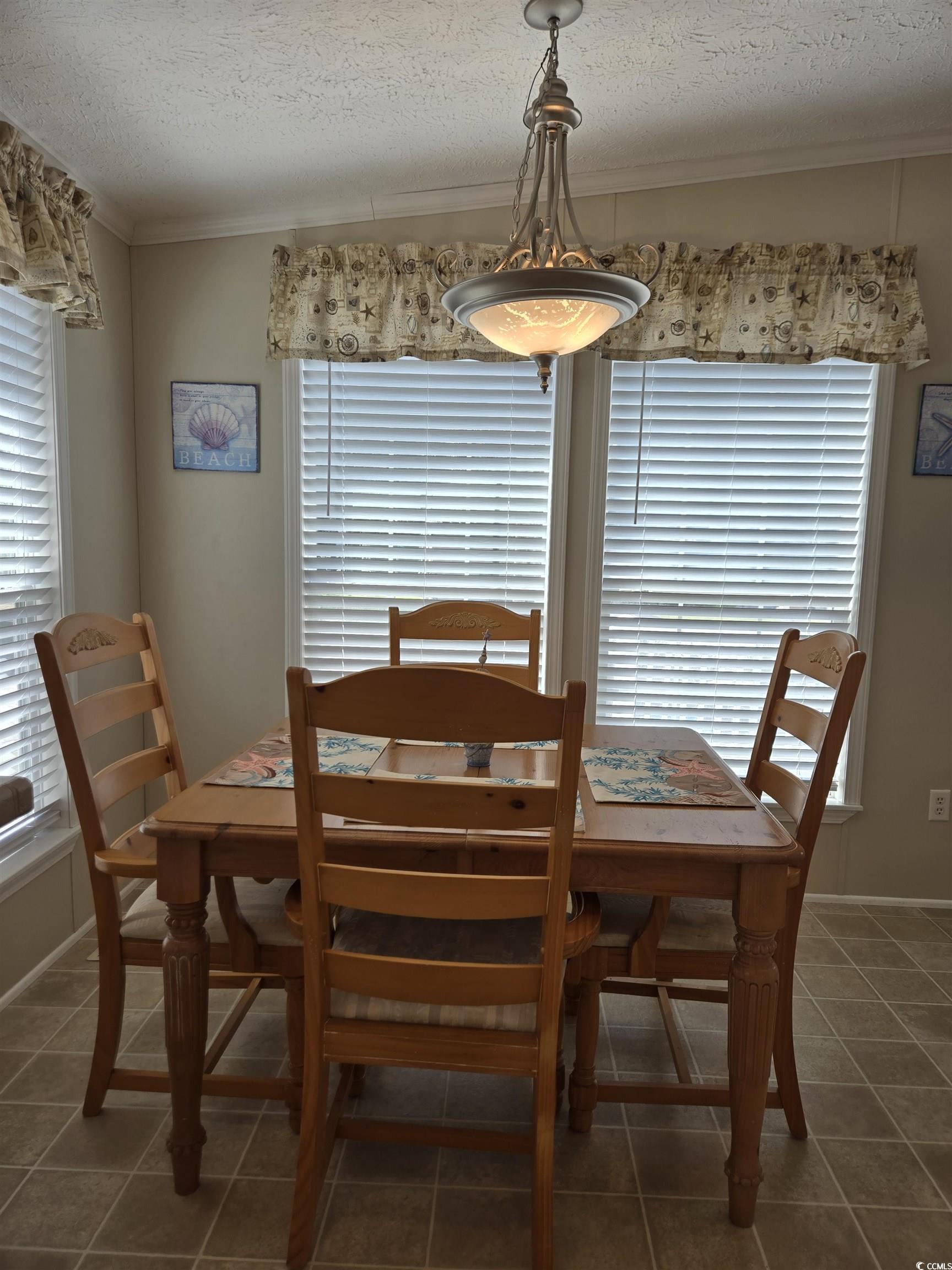 337 Clam Shell Circle Murrells Inlet, SC 29576 - Photo 16 of 29 Dining space with plenty of natural light, a textured ceiling, tile patterned floors, and crown molding
