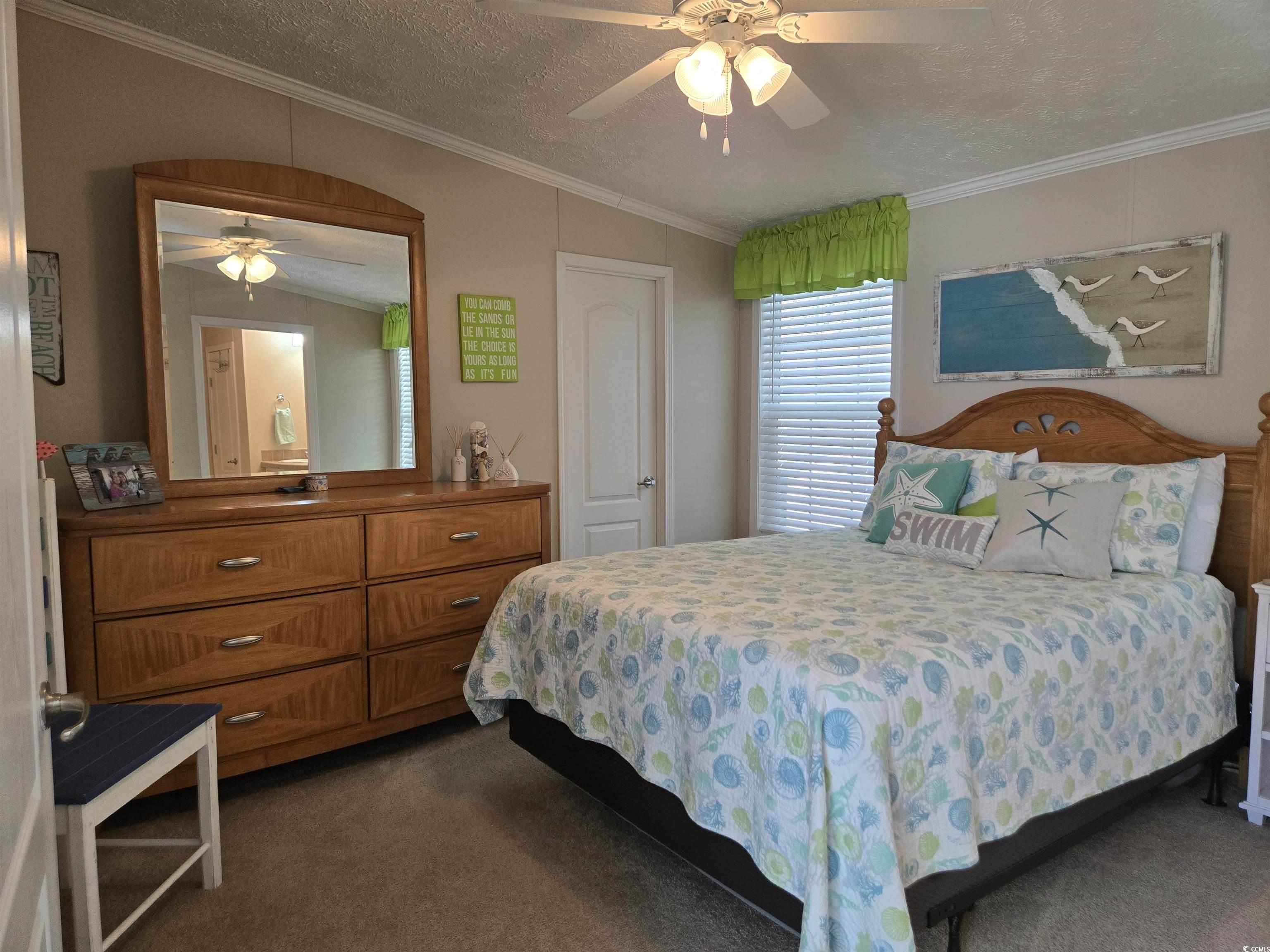 337 Clam Shell Circle Murrells Inlet, SC 29576 - Photo 18 of 29 Bedroom featuring dark colored carpet, crown molding, a textured ceiling, a ceiling fan, and lofted ceiling