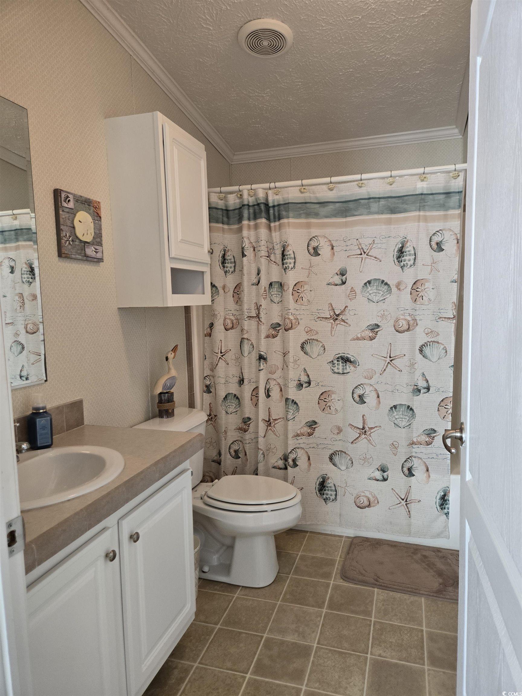 337 Clam Shell Circle Murrells Inlet, SC 29576 - Photo 23 of 29 Bathroom featuring ornamental molding, vanity, a textured ceiling, tile patterned flooring, and a shower with curtain