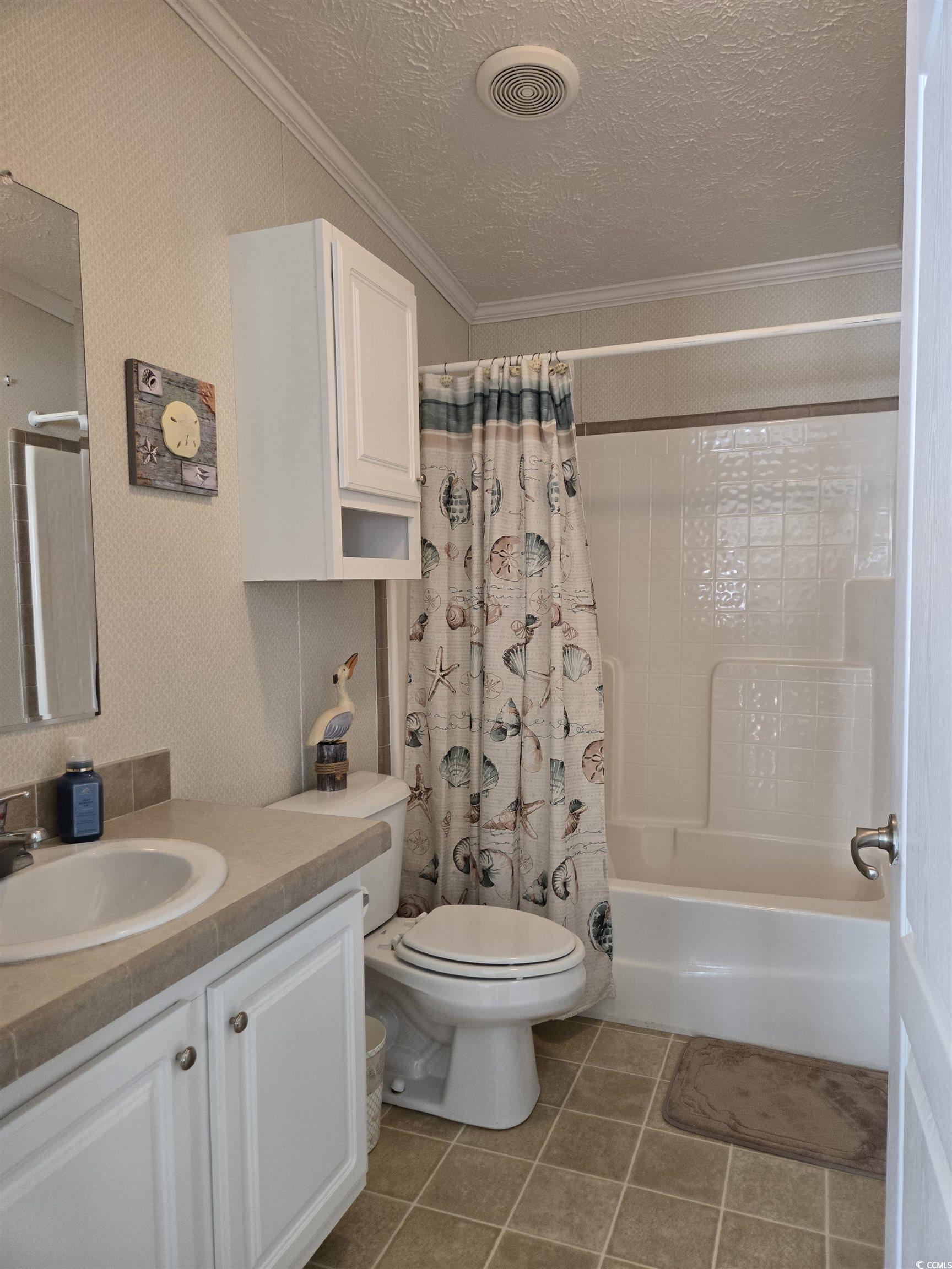 337 Clam Shell Circle Murrells Inlet, SC 29576 - Photo 24 of 29 Bathroom with crown molding, a textured ceiling, vanity, shower / bathtub combination with curtain, and tile patterned floors