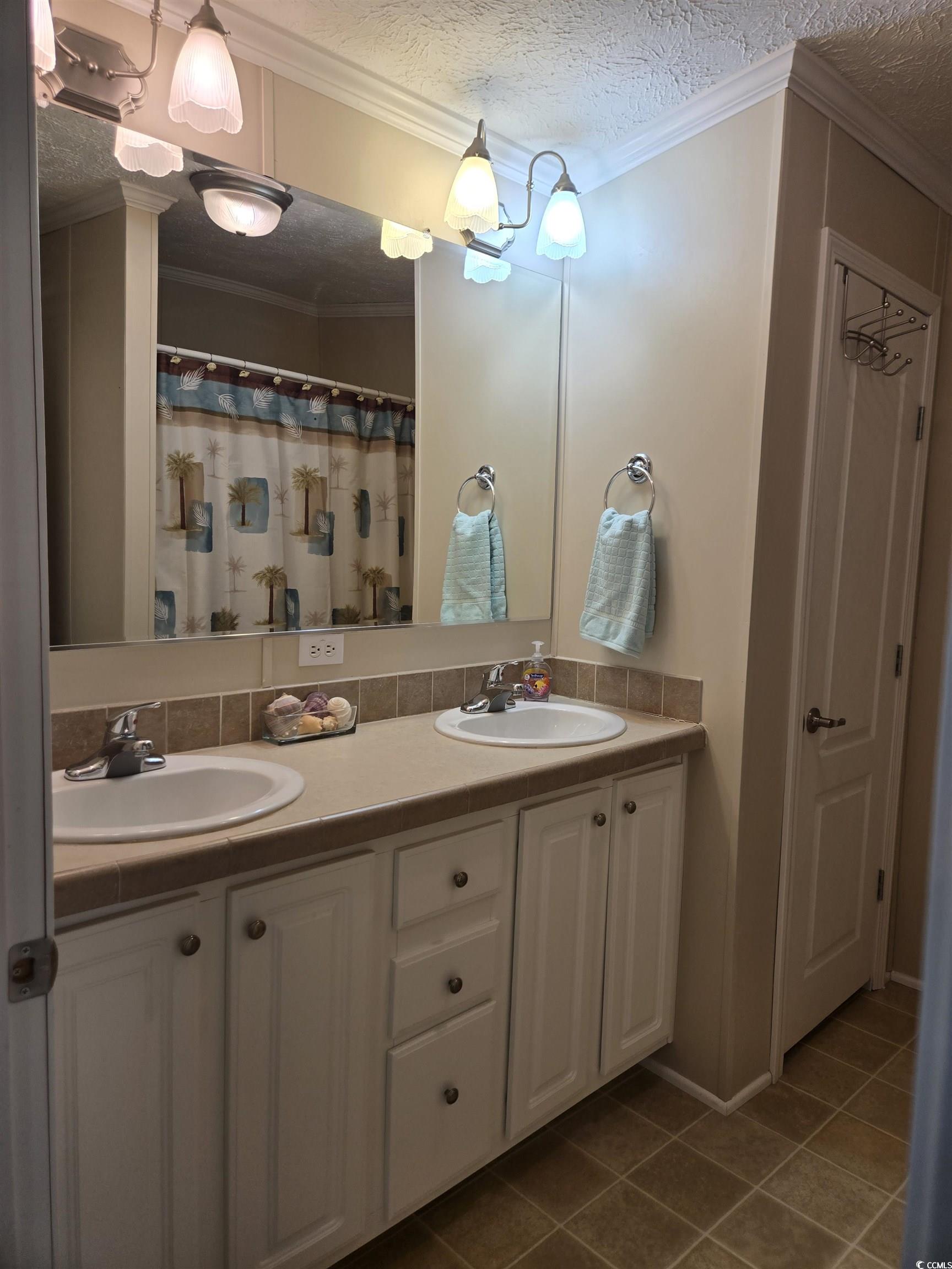 337 Clam Shell Circle Murrells Inlet, SC 29576 - Photo 28 of 29 Bathroom featuring double vanity, a textured ceiling, tile patterned floors, and crown molding