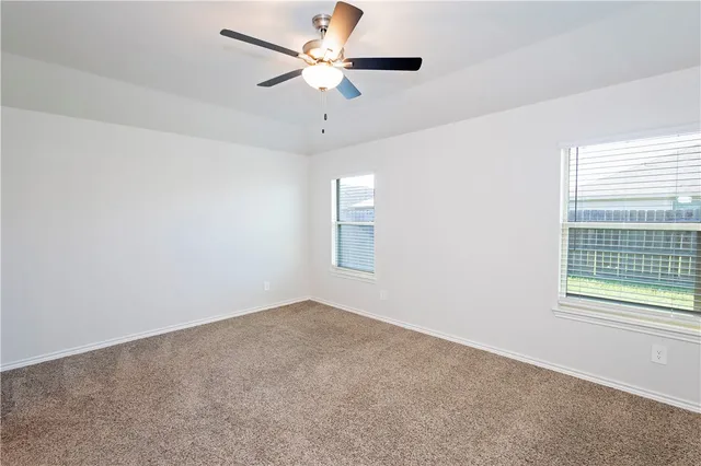 an empty room with a window and a fan