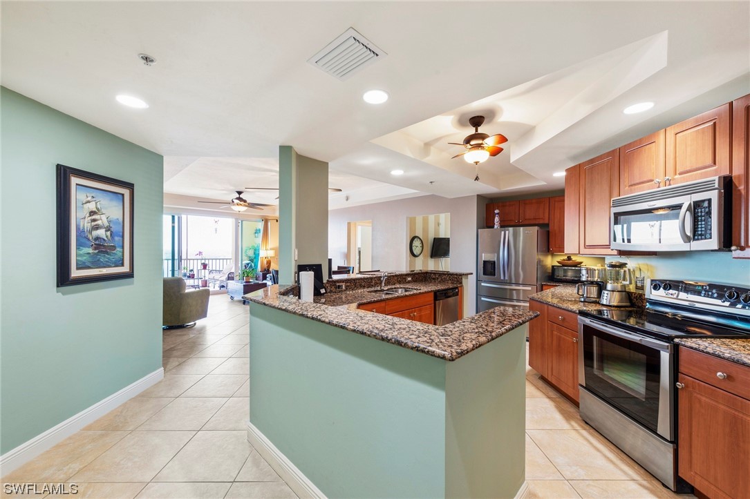 a kitchen with stainless steel appliances granite countertop a sink a stove top oven and cabinetry