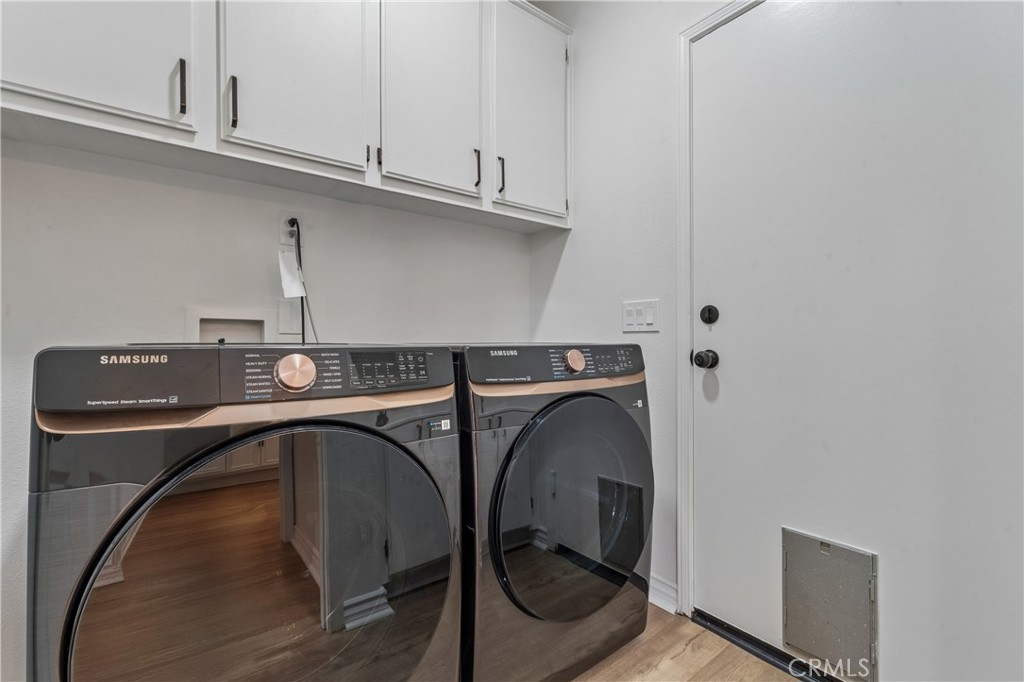26023 Salinger Lane Stevenson Ranch, CA 91381 - Photo 13 of 35 Laundry room featuring built-in cabinetry and a utility sink.