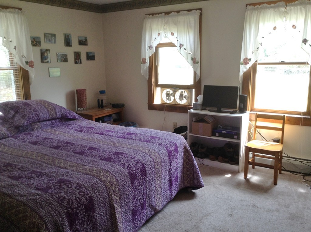69 East Main Street Rindge, NH 03461 - Photo 16 of 27 a bedroom with a bed and a tv on table