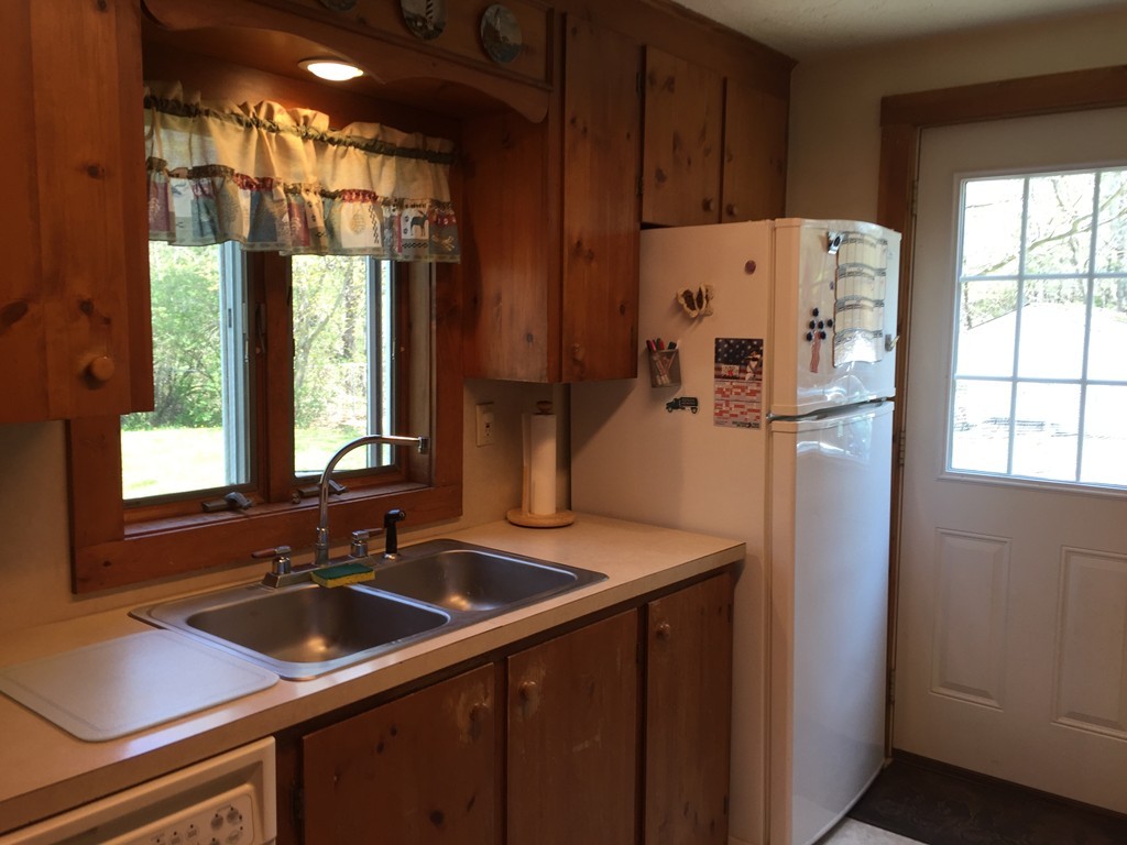 69 East Main Street Rindge, NH 03461 - Photo 10 of 27 a kitchen with stainless steel appliances a sink a refrigerator a counter and a window