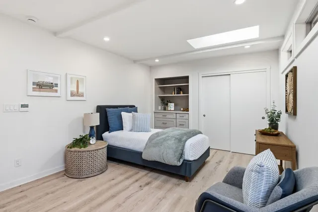 a bedroom with a large bed and a potted plant