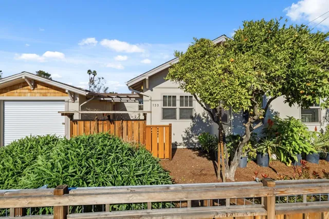 a view of a houses with a yard from a balcony