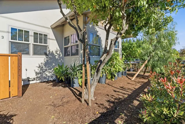 a view of a house with a small yard and potted plants