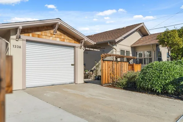 an aerial view of a house with a yard potted plants and large tree