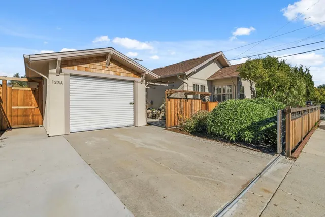 a front view of a house with a yard and potted plants