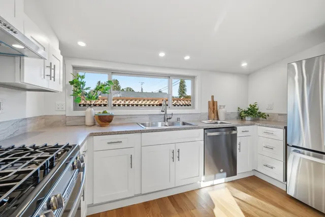 a kitchen with stainless steel appliances a sink stove and refrigerator