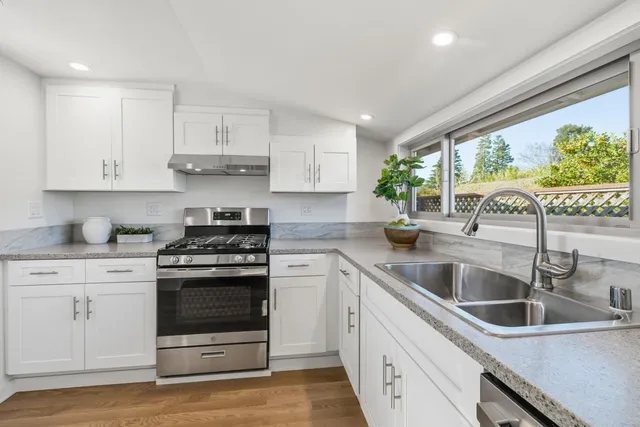 a kitchen with stainless steel appliances granite countertop refrigerator sink and cabinets