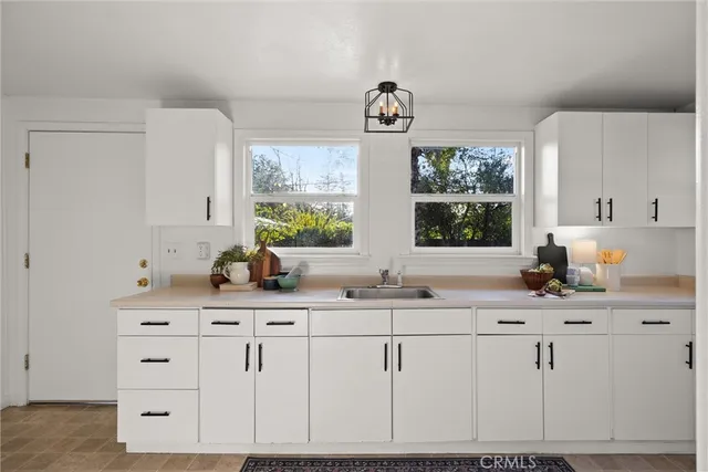 a kitchen with granite countertop a sink cabinets and window