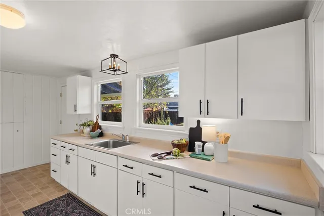 a kitchen with white cabinets and white appliances