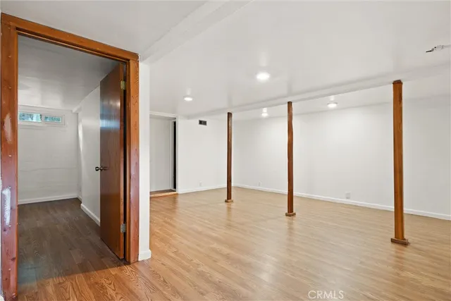 a view of empty room with wooden floor