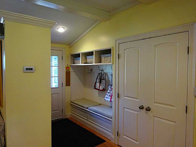 48 Pleasant Street Portsmouth, RI 02871 - Photo 15 of 25 Entry. A custom built mudroom was designed for the family room entryway. Benches to the left and right have storage underneath and storage areas up above The partition to the left was built to function as a room divider as well as for storage.