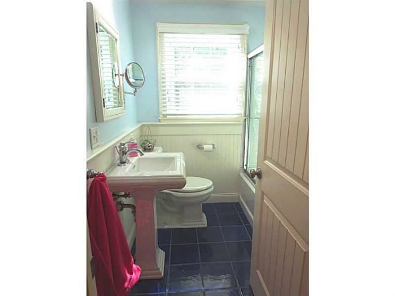 48 Pleasant Street Portsmouth, RI 02871 - Photo 24 of 25 Bathroom. This bath has tile flooring, beadboard and a tub and shower enclosed with a glass door. There is a linen closet in the hallway