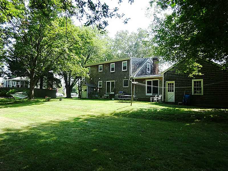 48 Pleasant Street Portsmouth, RI 02871 - Photo 4 of 25 Yard/Garden. This is a view of the back of the house. The door to the left leads to the basement. A deck was planned to connect the sliding doors in the kitchen dining area to the sliders in the family room. Also visible is the exterior door leading into the garage.