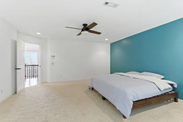 a bedroom with a bed and a ceiling fan