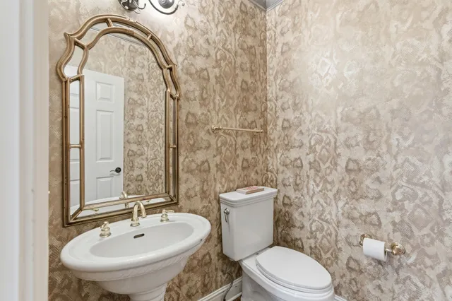 a bathroom with a toilet sink and mirror